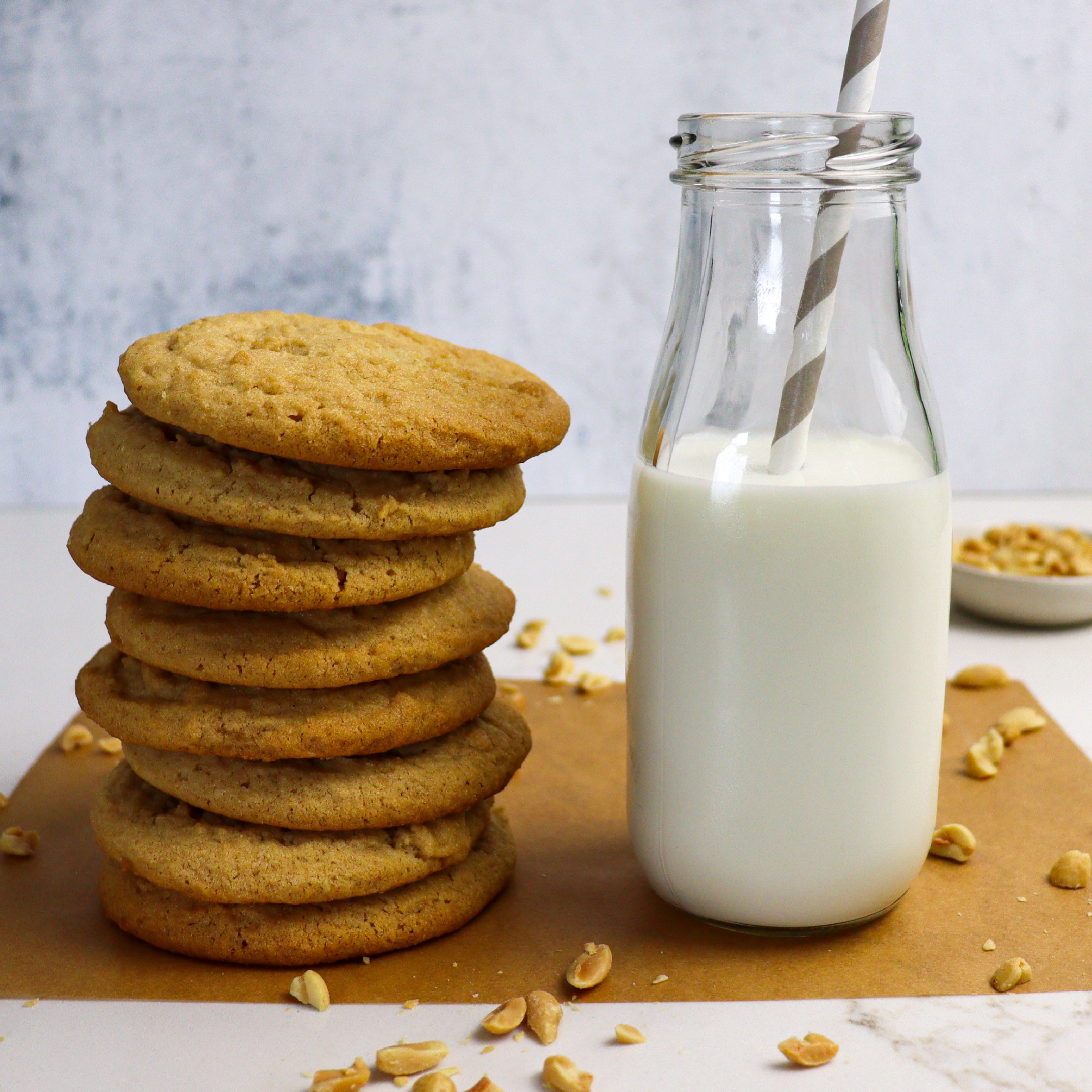 Stack of chewy peanut butter cookies with glass of milk