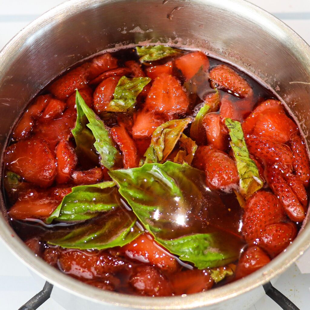 Strawberry simple syrup simmering on stove