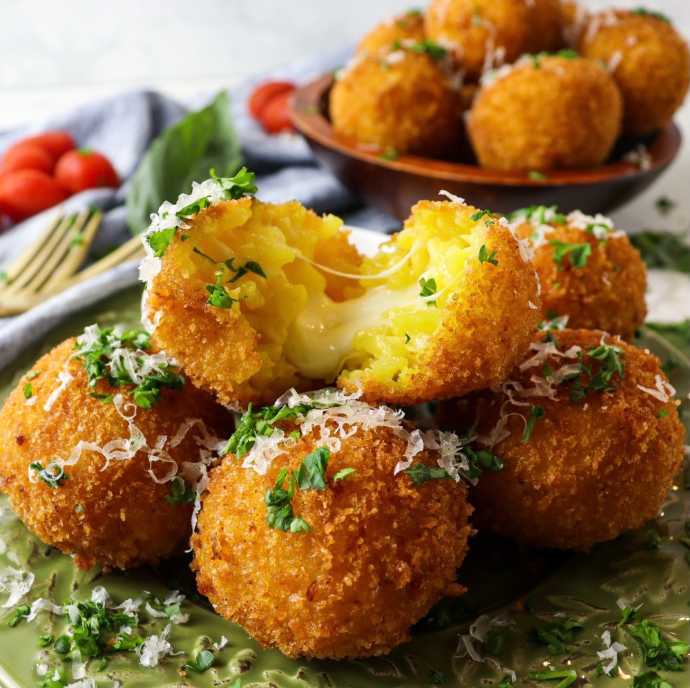 Pulled apart mozzarella stuffed arancini or Italian rice balls