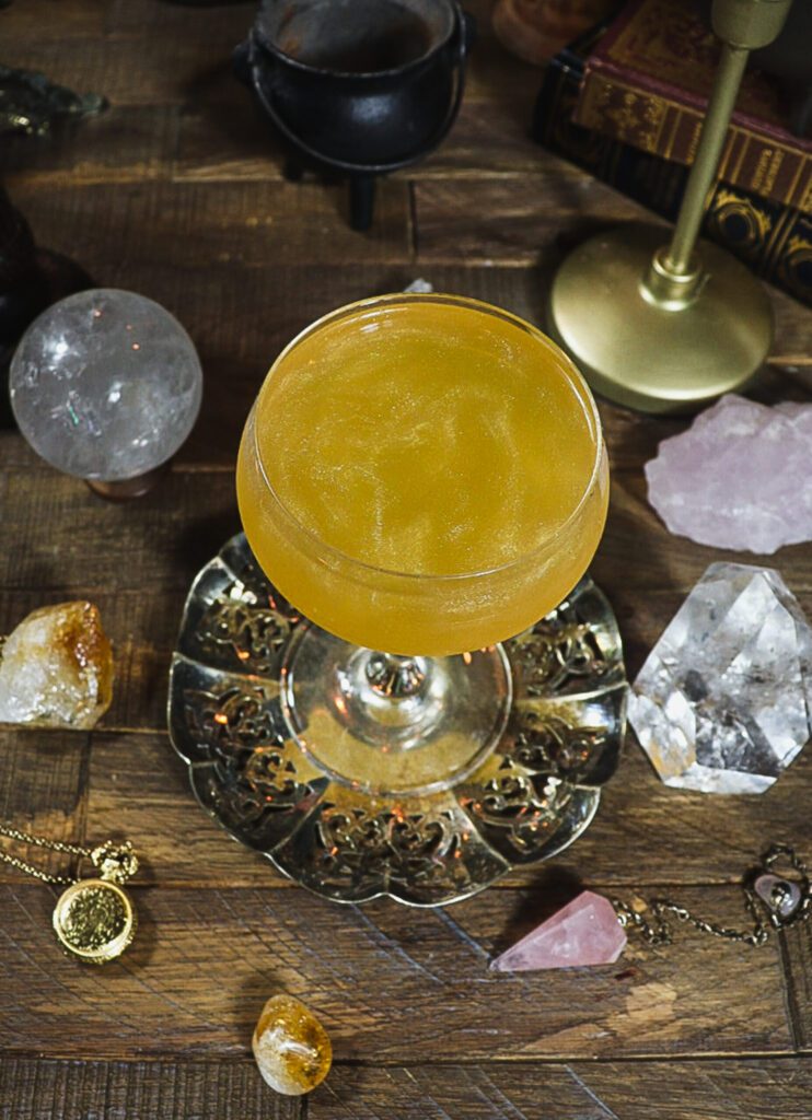 the Felix felicis potion cocktail in a beautiful coop glass on a table