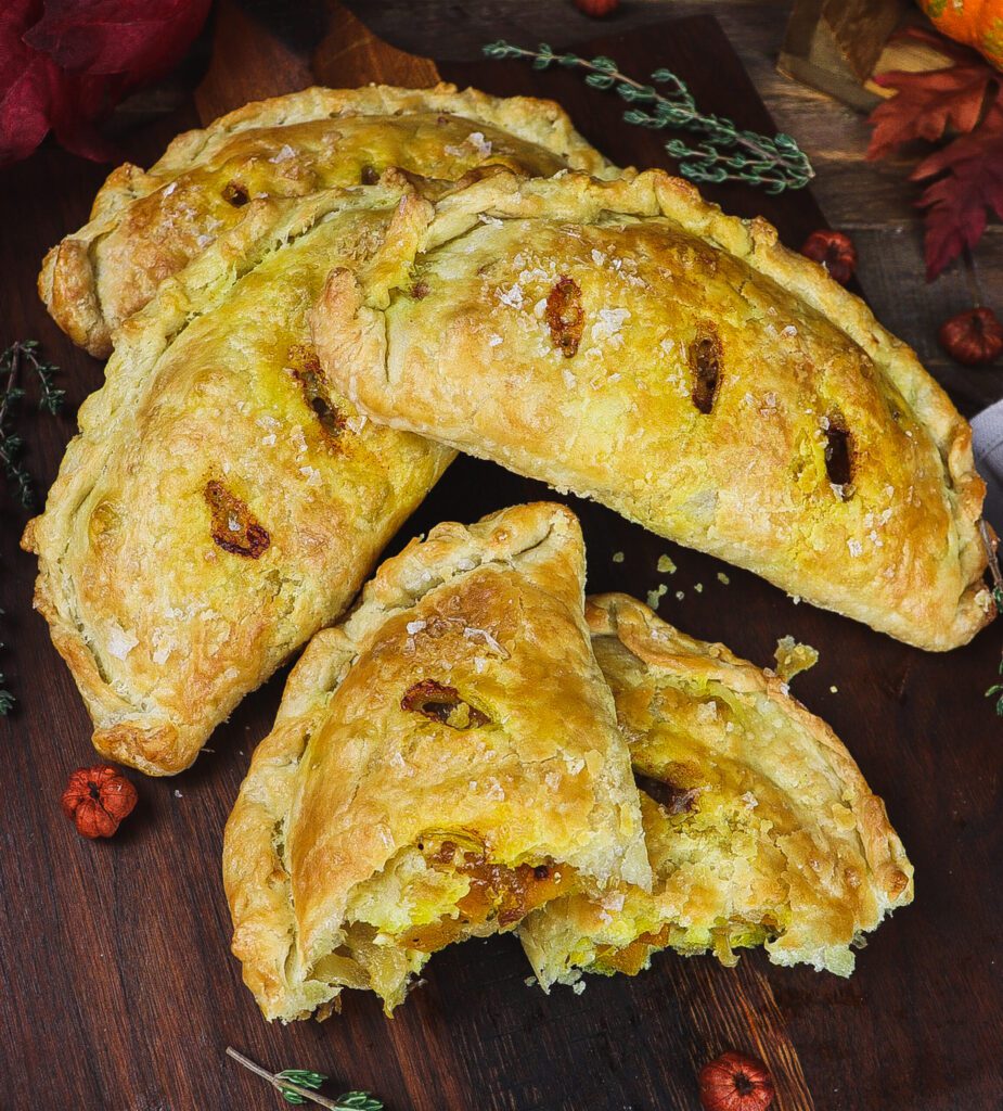 Four pumpkin pasties on a cutting board