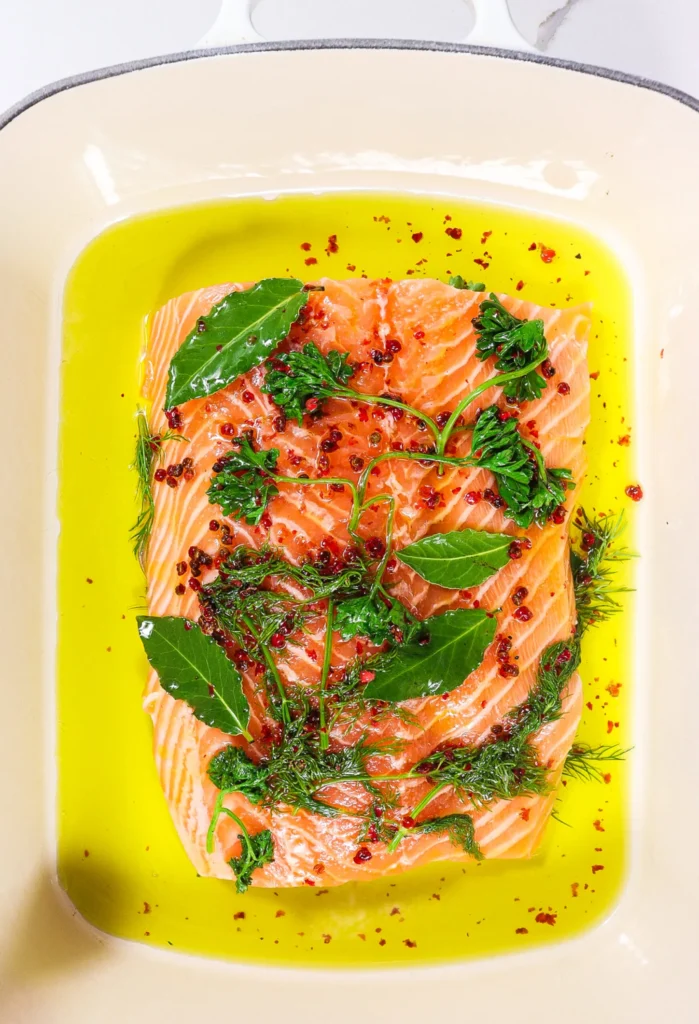 Pink salmon in a baking dish covered in infused oil