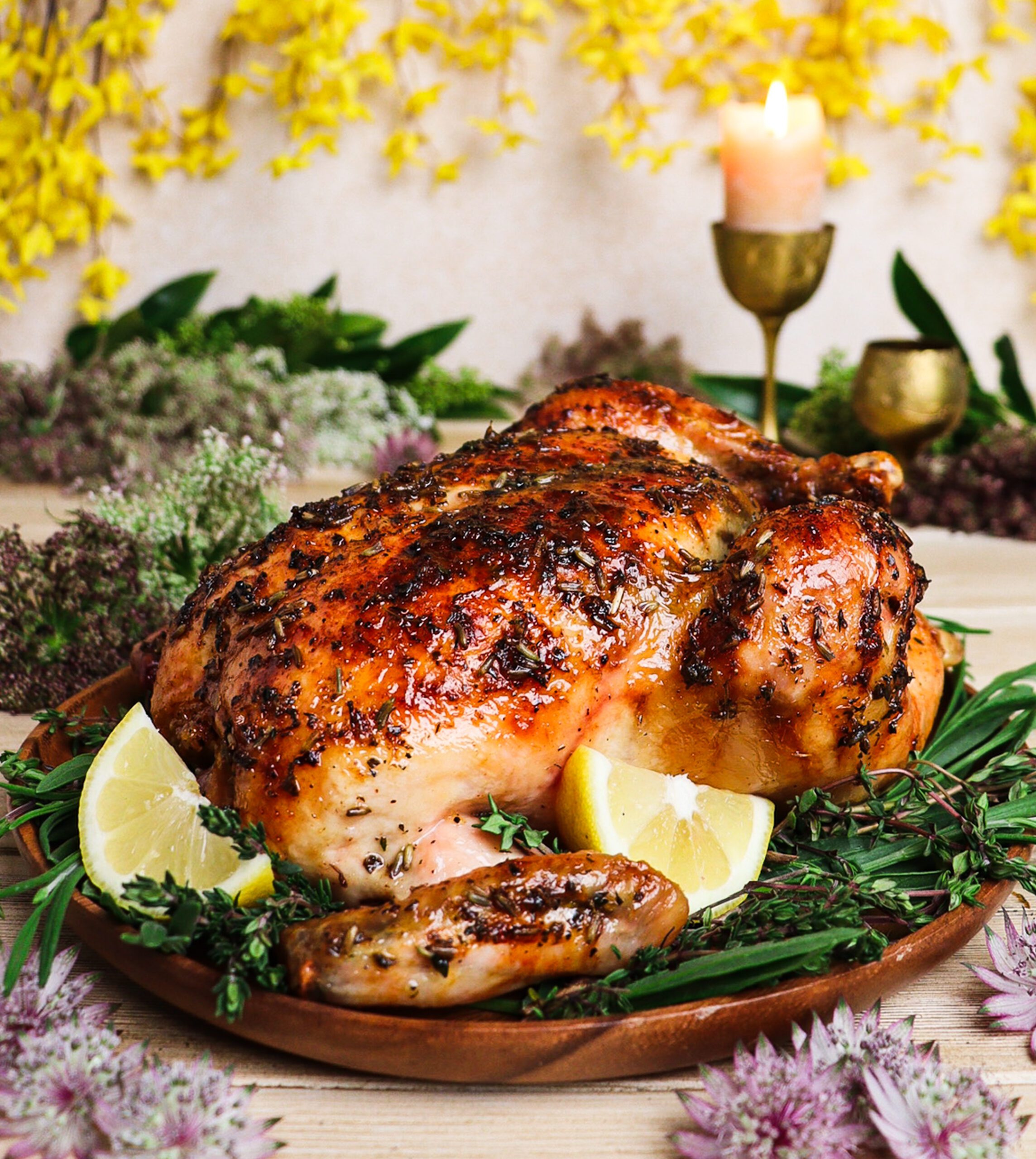 Roast chicken glazed with honey  lavender sauce surrounded by yellow flowers and woodland greenery inspired by Lothlórien