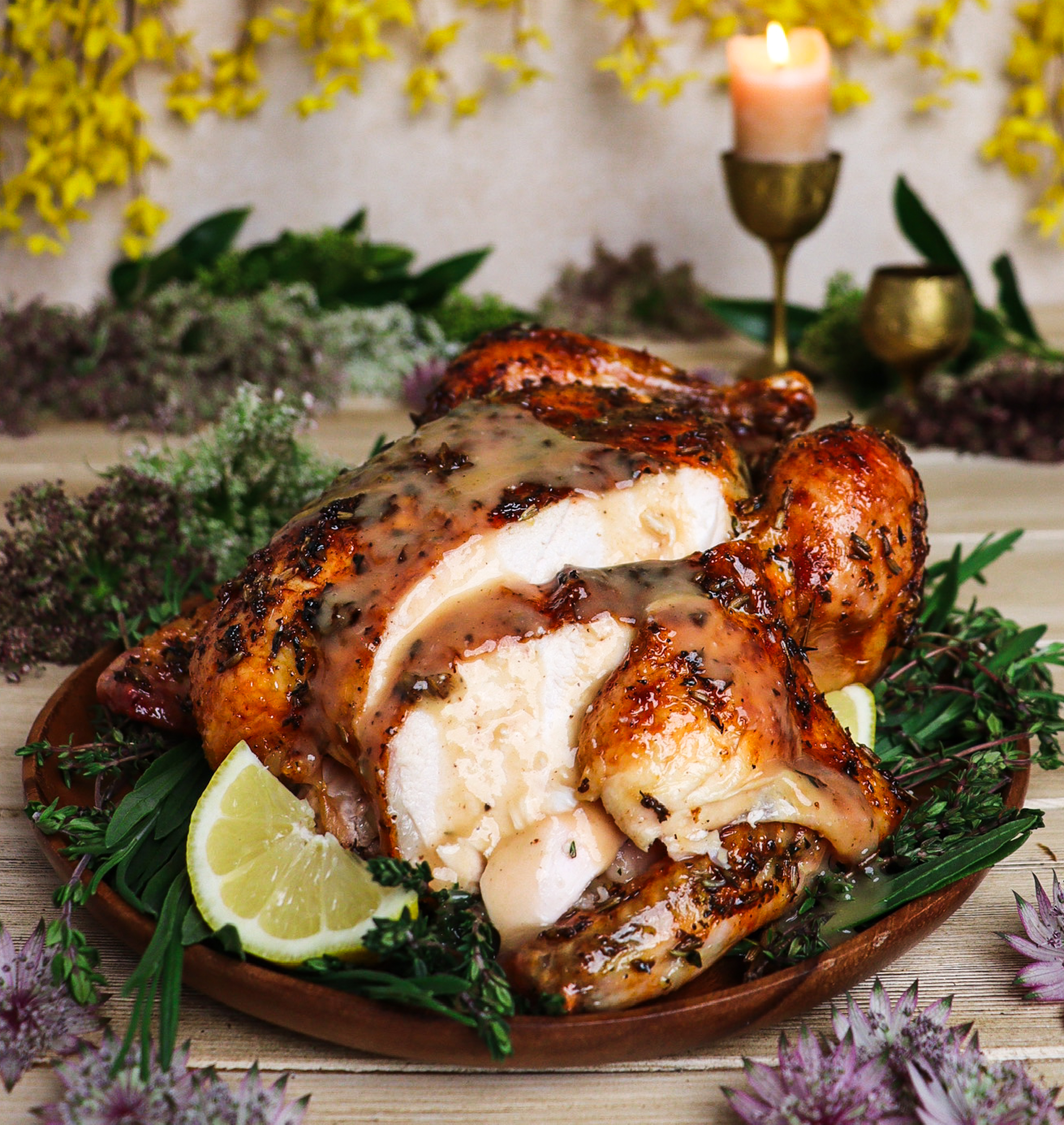 Roast chicken glazed with honey lavender sauce surrounded by yellow flowers and woodland greenery inspired by Lothlórien