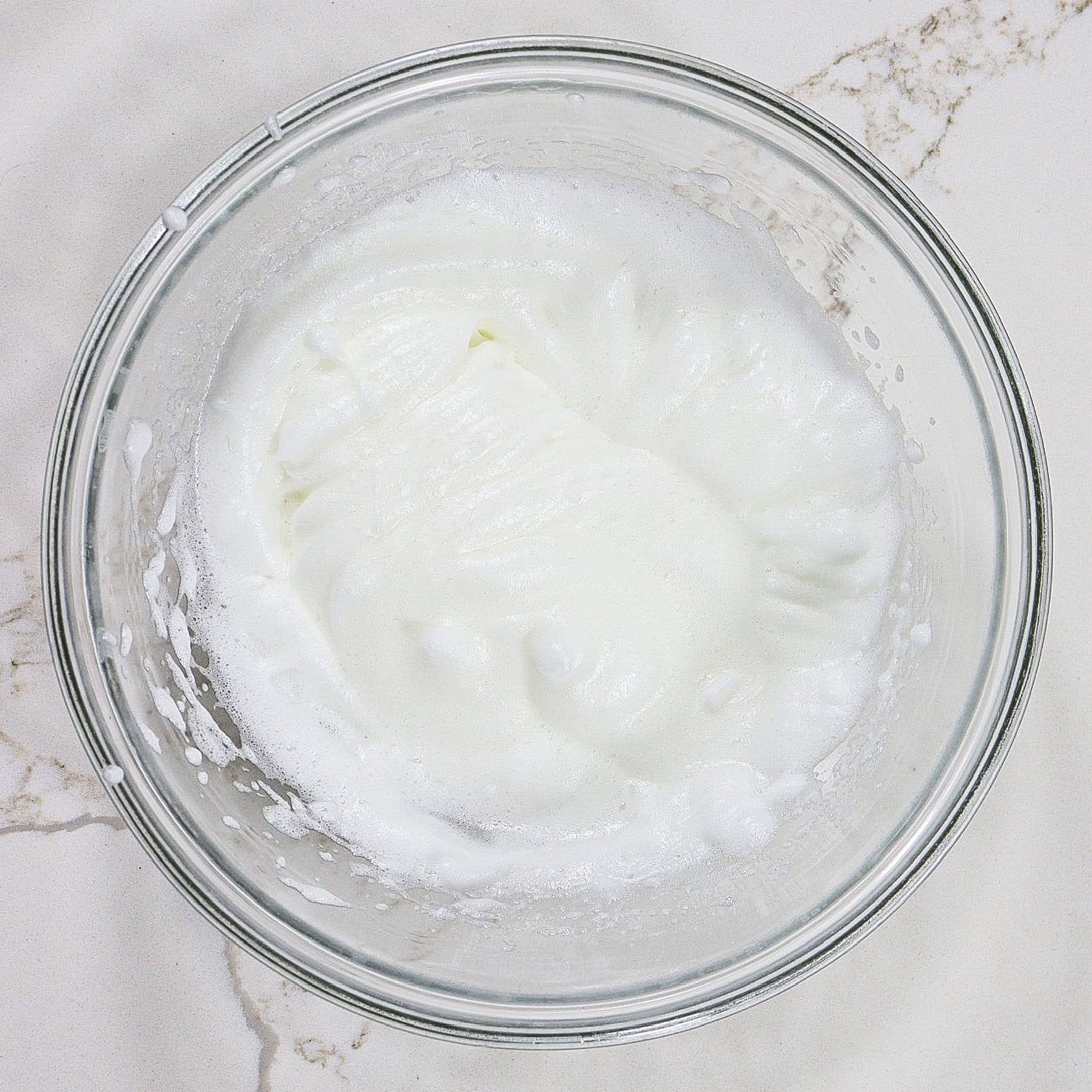 whipped egg whites in a mixing bowl for waffle batter