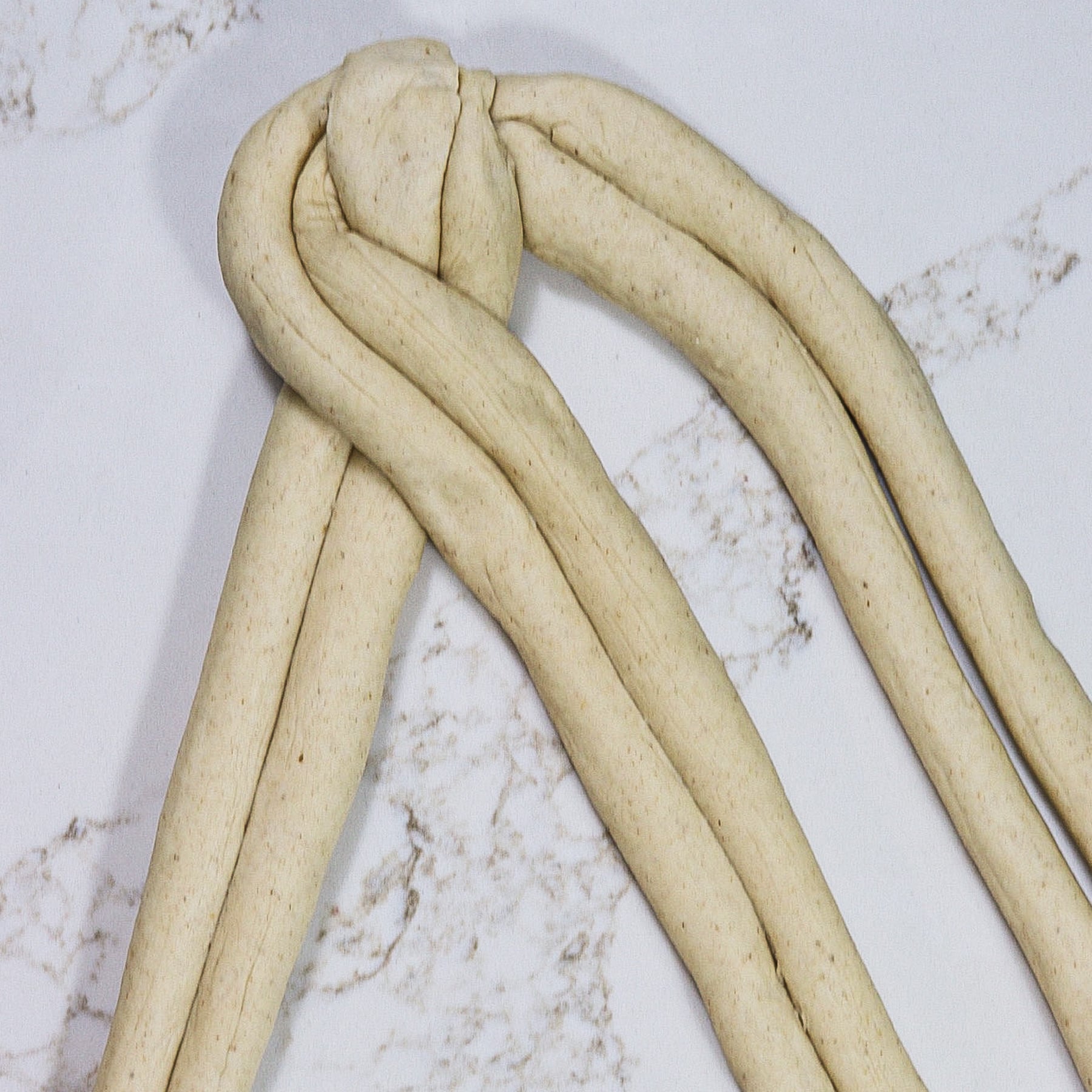 Braiding three double strand ropes of soft barley bread dough