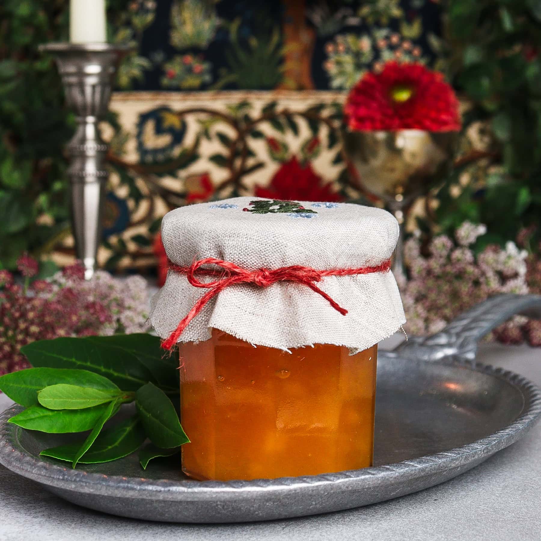 Canned peach and bay leaf jam on a silver platter 