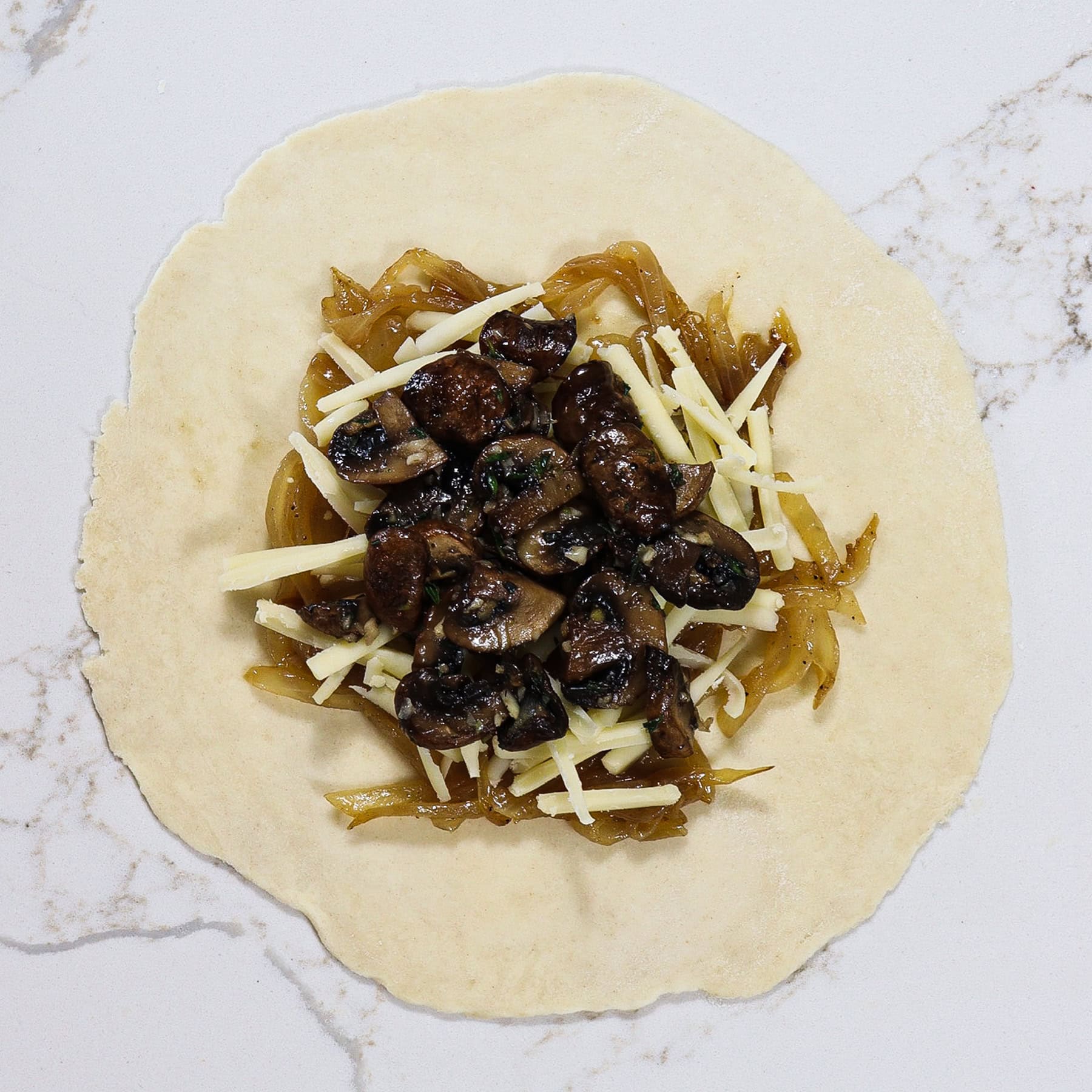 pie dough topped with caramelized onions, cheese and mushrooms
