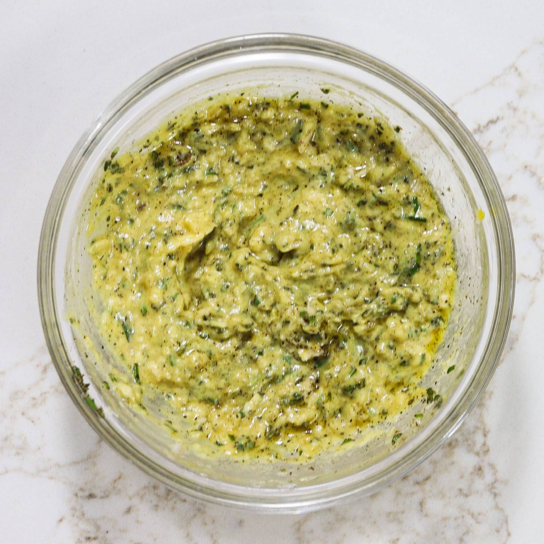 mustard and horseradish marinade in a mixing bowl with herbs