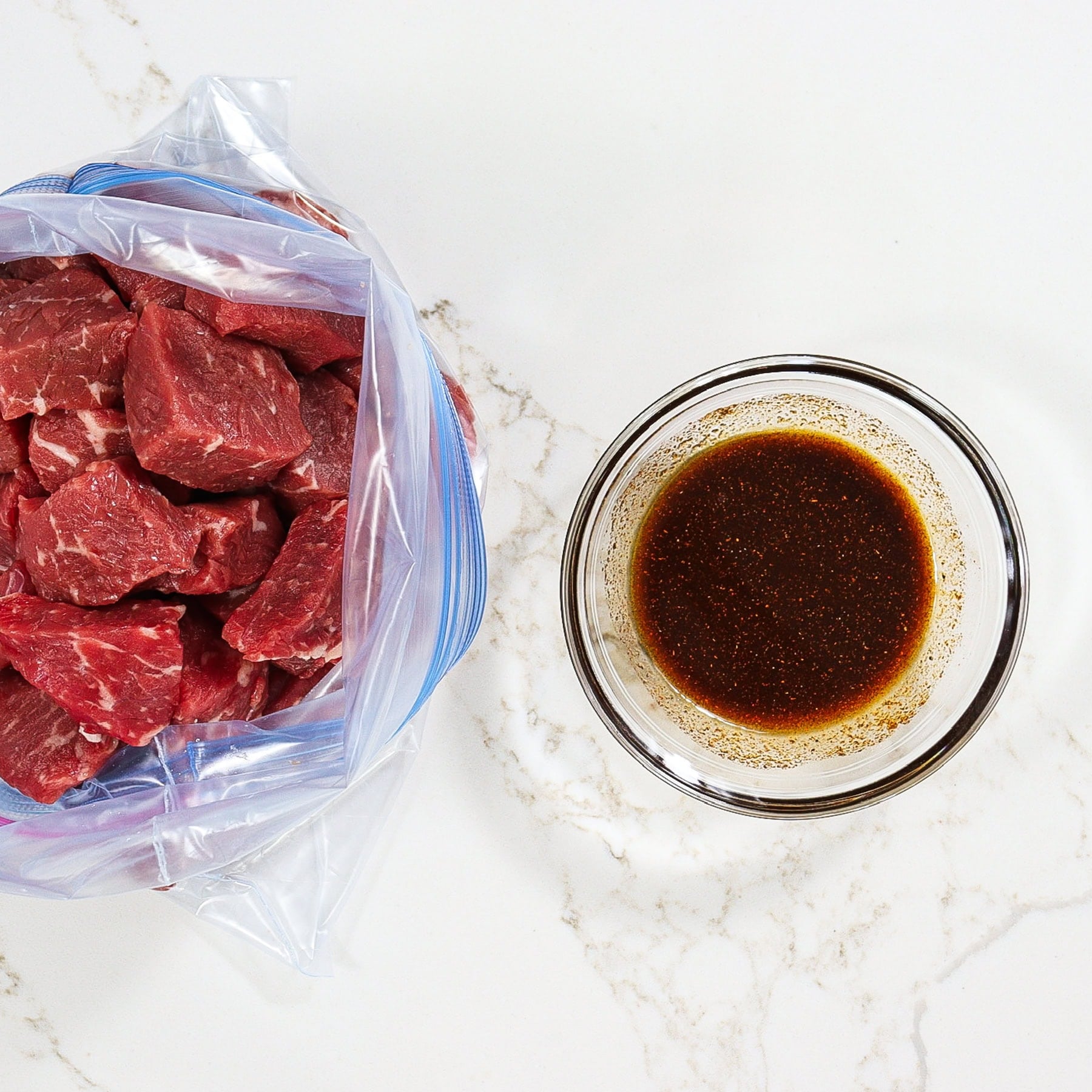 steak cubes in a ziploc bag before marinating with paprika marinade in a mixing bowl