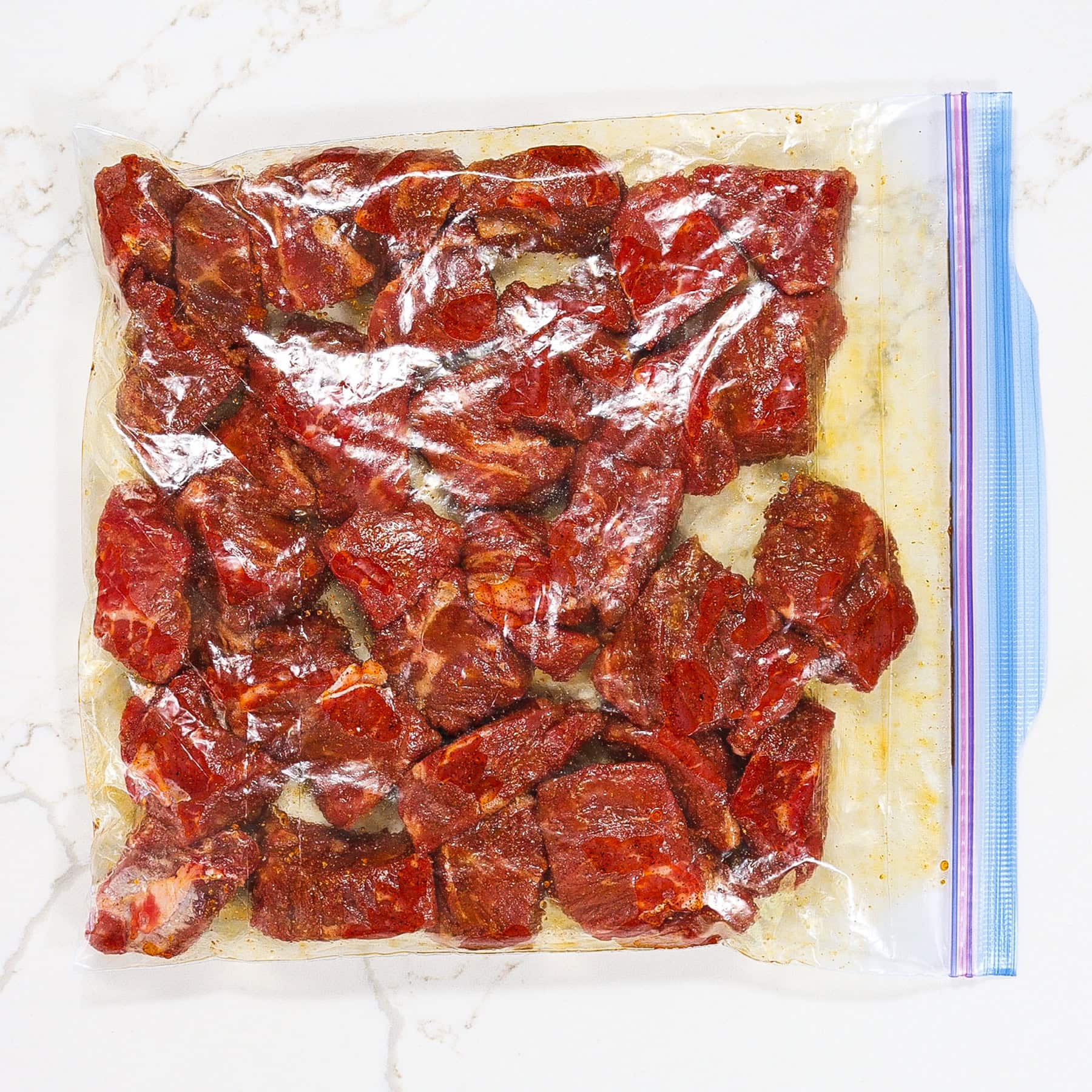 steak cubes in a ziploc bag marinating in a paprika garlic marinade