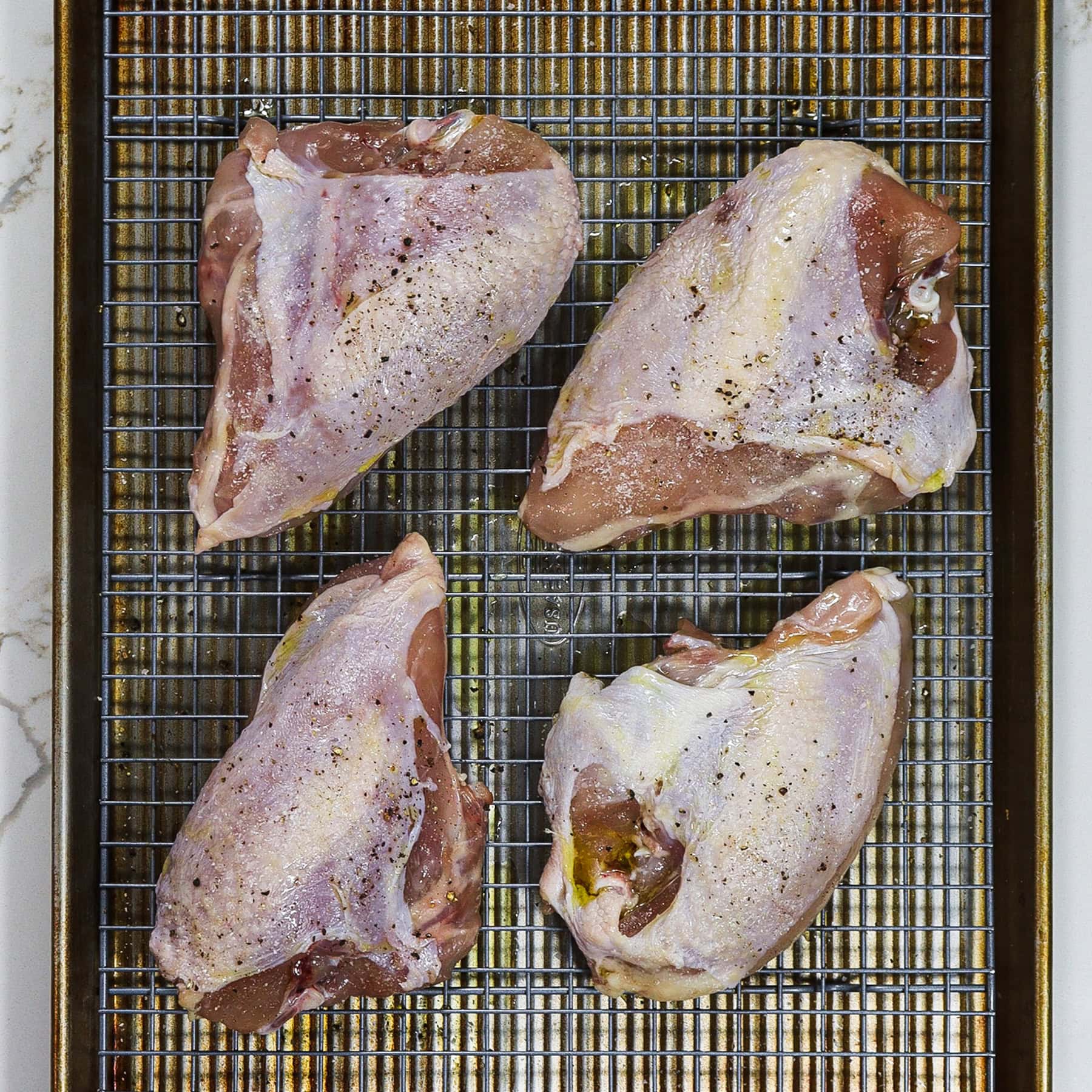 chicken breasts on a rack and sheet pan for roasting