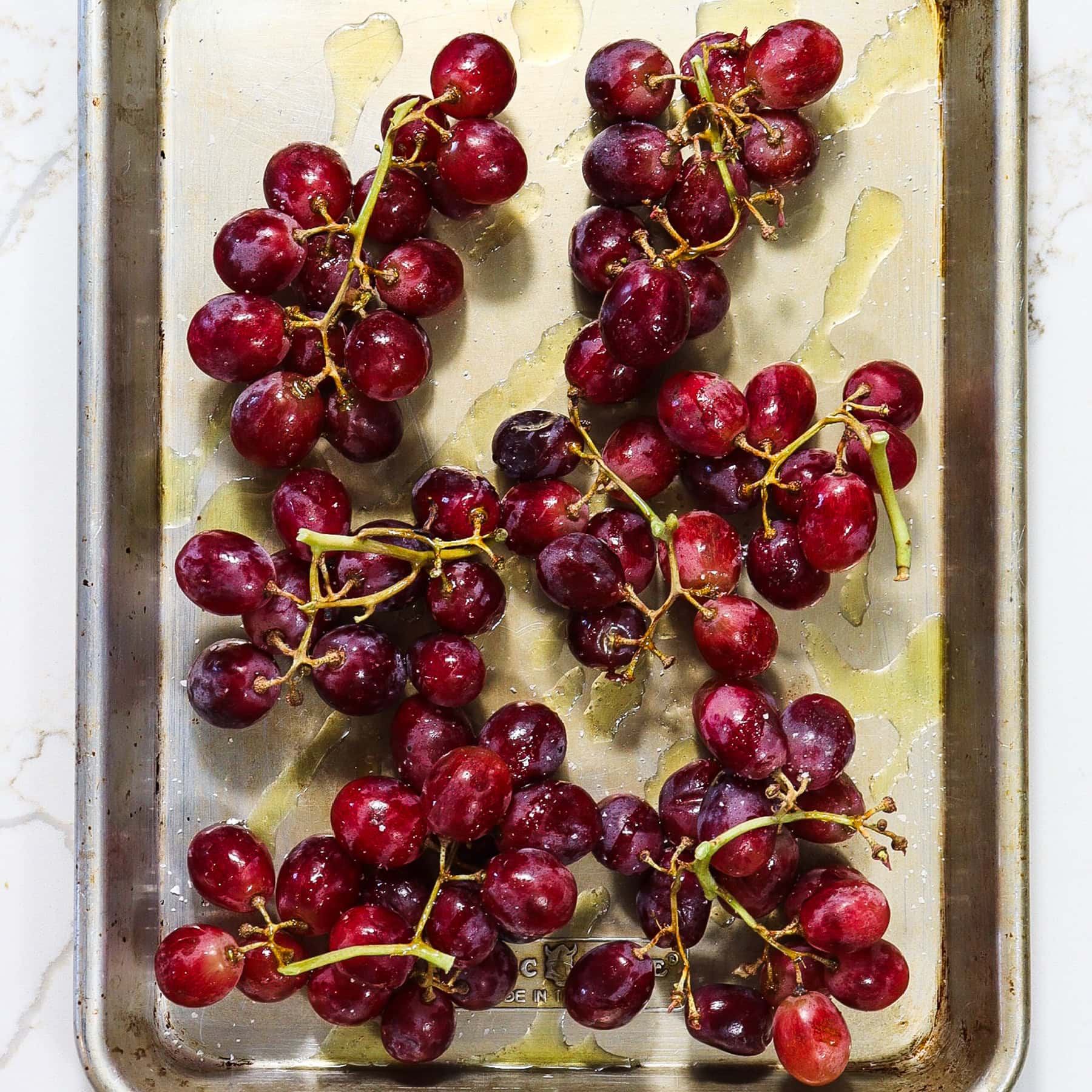 red grapes on a sheet pan with olive oil for roasting