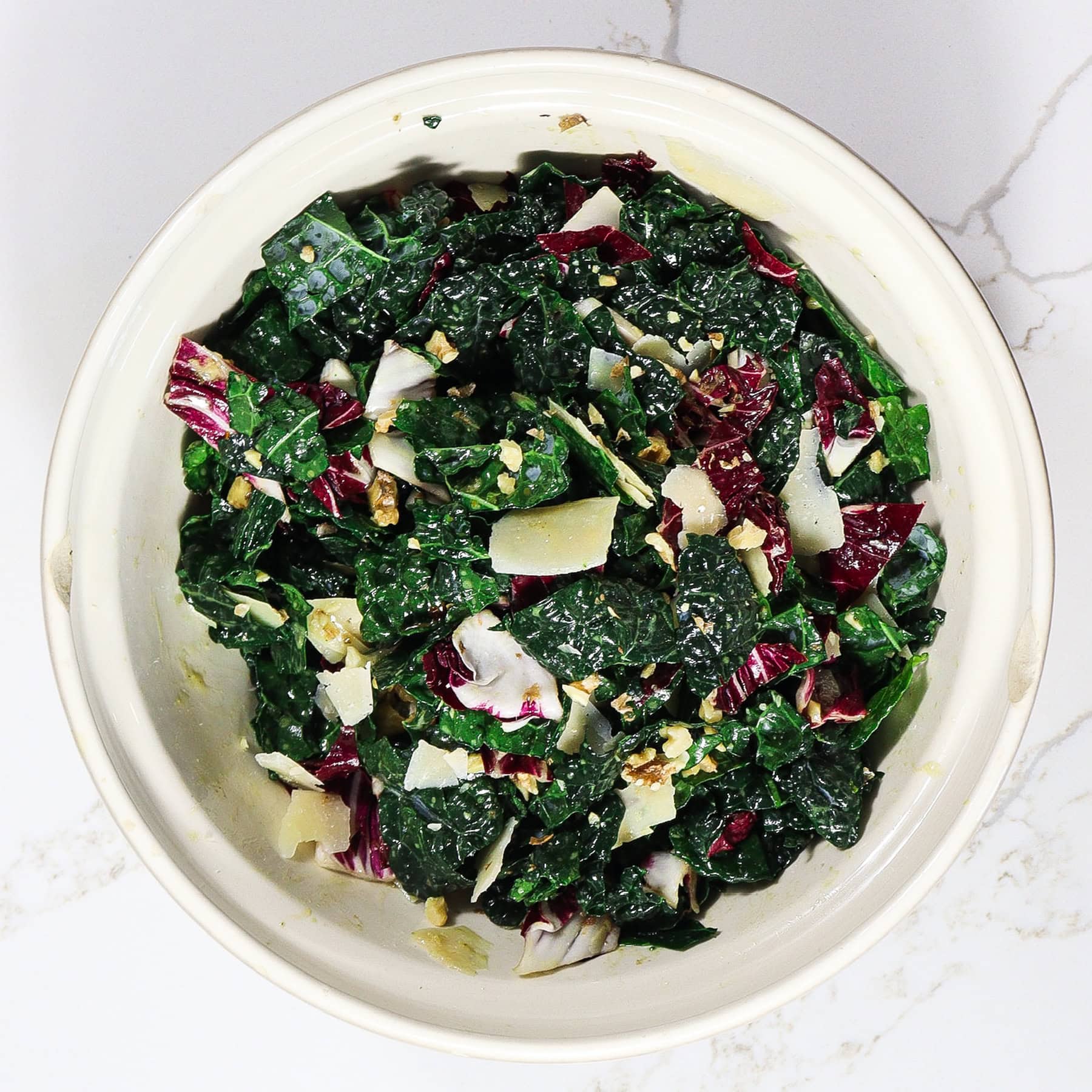 kale, radicchio, walnuts and cheese with sweet wine vinaigrette in a mixing bowl for chicken salad with grapes